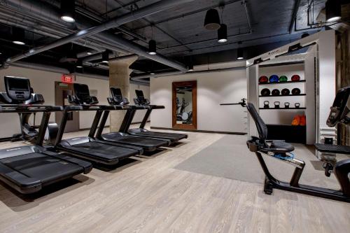 a gym with treadmills and elliptical machines at Embassy Suites By Hilton Rockford Riverfront in Rockford