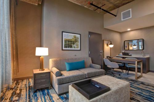 uma sala de estar com um sofá e uma mesa em Embassy Suites By Hilton Rockford Riverfront em Rockford