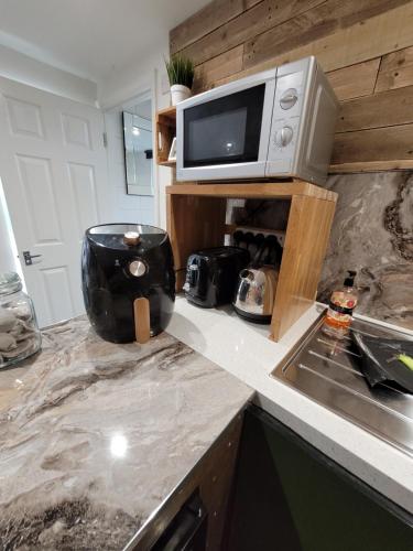 a kitchen counter with a microwave and a sink at Willow Inn in Kent