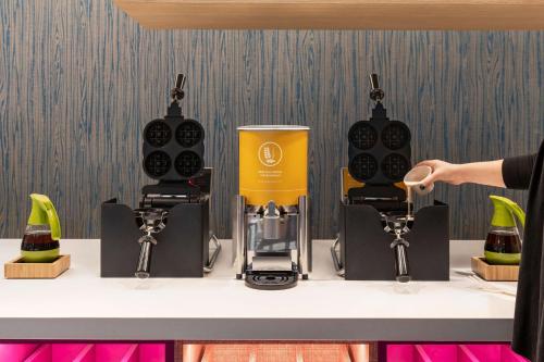 a person holding a cup in front of a coffee maker at Home2 Suites By Hilton Glen Mills Chadds Ford in Glen Mills