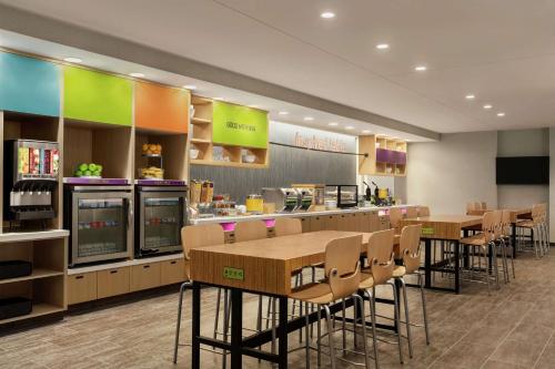 a restaurant with tables and chairs in a cafeteria at Home2 Suites By Hilton Glen Mills Chadds Ford in Glen Mills
