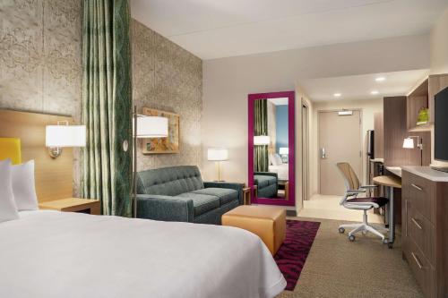 Glen MillsにあるHome2 Suites By Hilton Glen Mills Chadds Fordのベッドとデスクが備わるホテルルームです。