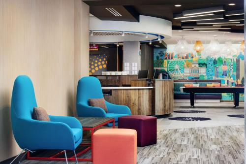 a lobby with chairs and a table and a piano at Tru By Hilton Atlanta Northlake Parkway, Ga in Atlanta