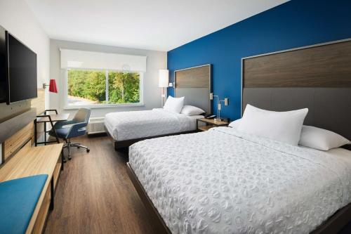 a hotel room with two beds and a flat screen tv at Tru By Hilton Atlanta Northlake Parkway, Ga in Atlanta