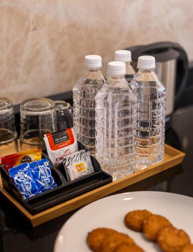a tray with bottles of water and food on a table at The Silver Chimes Suites in Bengaluru