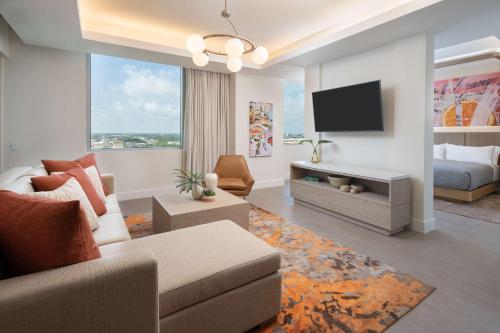 a living room with a couch and a tv at Canopy West Palm Beach - Downtown in West Palm Beach