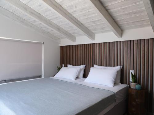 a bedroom with a large bed with a wooden wall at Perla al Mare in Adelianos Kampos