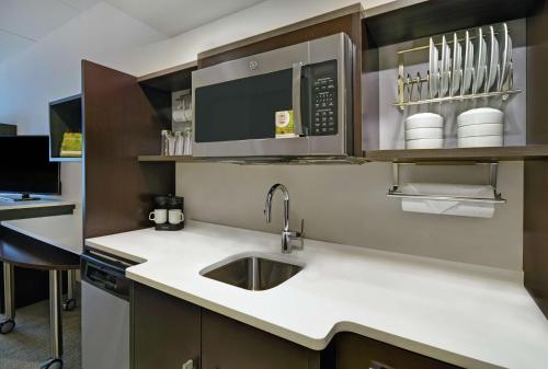 a kitchen with a sink and a microwave at Home2 Suites By Hilton Lawrenceville Atlanta Sugarloaf, Ga in Lawrenceville