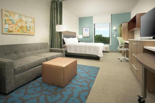 ケネソーにあるHome2 Suites By Hilton Atlanta Nw/Kennesaw, Gaのソファとベッド付きのホテルルーム