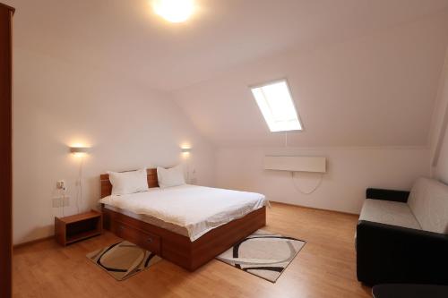 a small bedroom with a bed and a couch at Pensiunea Cavaler in Baile Felix