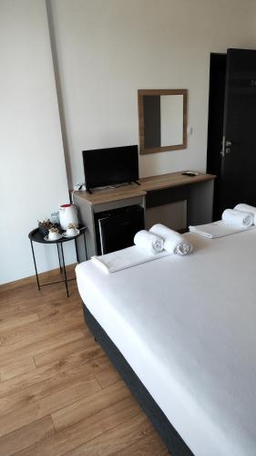 two beds in a room with a desk and a mirror at Marina Sarafovo in Burgas City