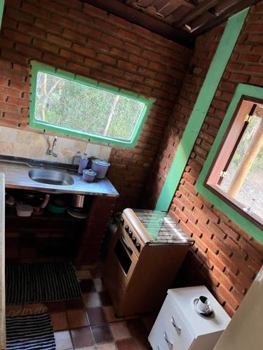 eine kleine Küche mit einer Spüle und einem Herd in der Unterkunft Sítio do pica pau amarelo in São Thomé das Letras
