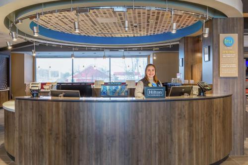 a woman standing at a counter in a lobby at Tru By Hilton Binghamton Vestal in Vestal