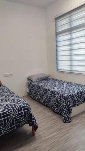 2 Betten in einem Zimmer mit Fenster in der Unterkunft Garlic Cherating Pool Homestay in Kampong Baharu Cherating