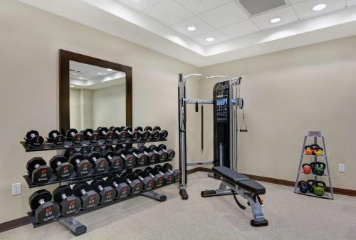 a gym with a wall of dumbbells and a mirror at Home2 Suites By Hilton Charleston Daniel Island, Sc in Charleston