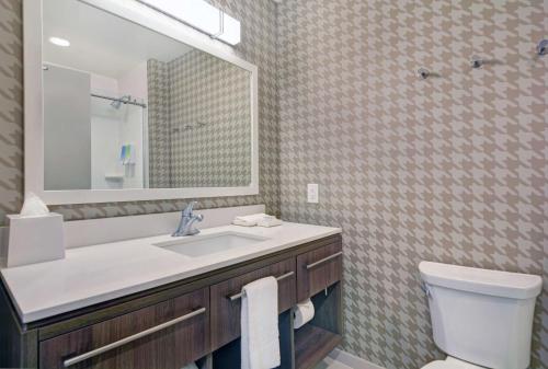 ein Badezimmer mit einem Waschbecken, einem WC und einem Spiegel in der Unterkunft Home2 Suites By Hilton Charleston Daniel Island, Sc in Charleston
