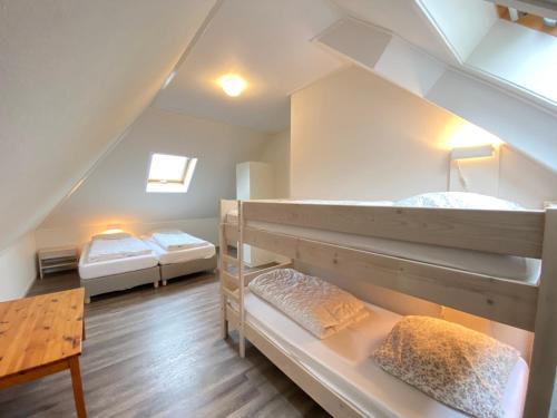 a room with two bunk beds and a table at Previnaireweg 25 in Callantsoog