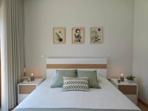 a bedroom with a white bed with two night stands at Casa da Milinha - Villa with a Pool near Rio Douro in Santa Cruz do Douro