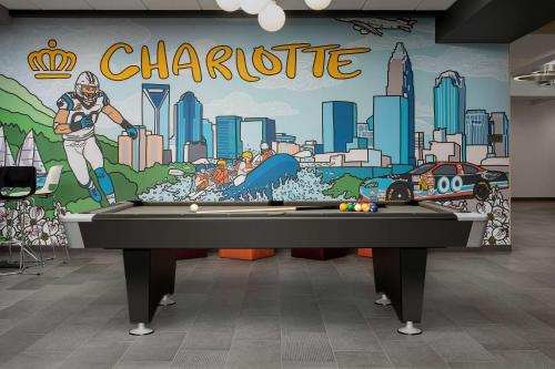 a pool table in a room with a mural at Tru By Hilton Charlotte Airport Lake Pointe in Charlotte