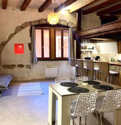 une cuisine avec une table et des chaises dans une pièce dans l'établissement L'atypique, bord du Thiou, à Annecy