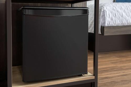 a black trash can on a shelf next to a bed at Tru By Hilton Charlotte Airport Lake Pointe in Charlotte