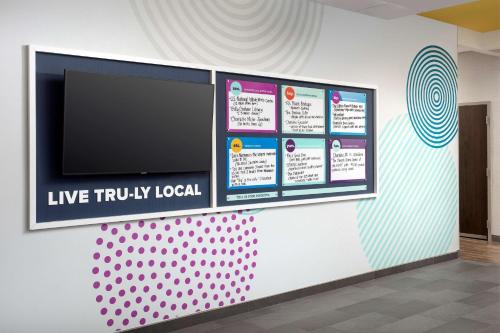 a wall with a flat screen tv on a wall at Tru By Hilton Charlotte Airport Lake Pointe in Charlotte