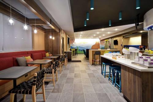 a restaurant with tables and chairs and a counter at Tru By Hilton Denver South Park Meadows, Co in Lone Tree