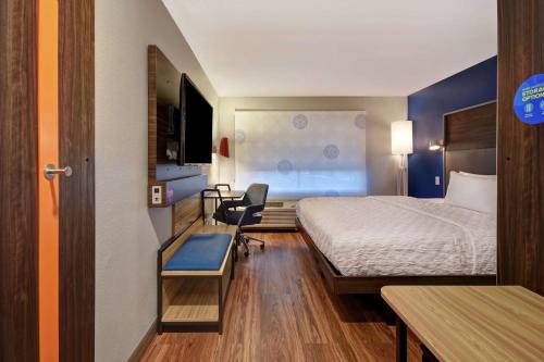 ein kleines Hotelzimmer mit einem Bett und einem Schreibtisch in der Unterkunft Tru By Hilton Denver South Park Meadows, Co in Lone Tree