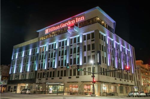 a building with a sign on top of it at night at Hilton Garden Inn Wichita Downtown, Ks in Wichita