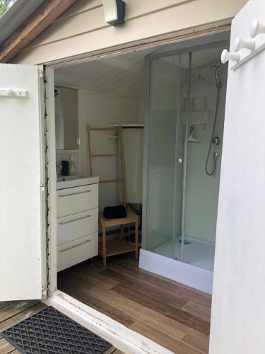 a bathroom with a shower and a glass door at Le Châlet des Hortillonnages in Amiens
