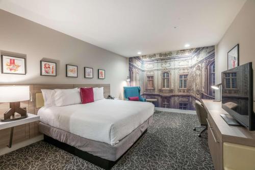 una camera d'albergo con letto, scrivania e TV di Hilton Garden Inn Wichita Downtown, Ks a Wichita
