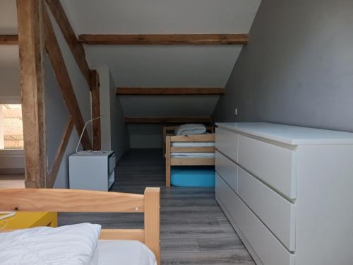 a attic room with a bed and a staircase at Loue appartement duplex de 90m2 refait à neuf in Villefort
