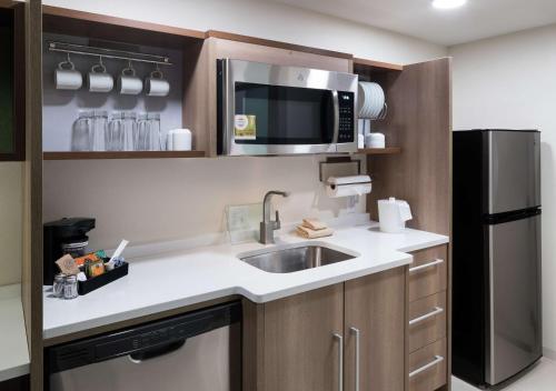 a small kitchen with a sink and a microwave at Home2 Suites By Hilton Jacksonville Airport in Jacksonville