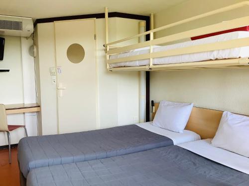 a room with a bed with two bunk beds at Première Classe Chateauroux - Saint Maur in Saint-Maur