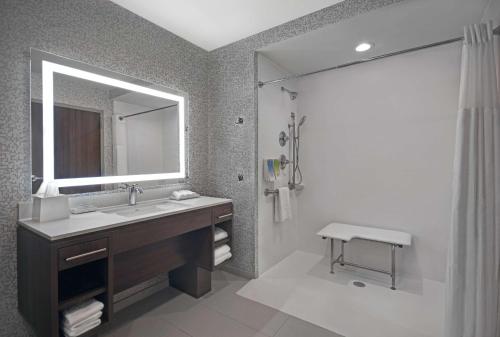 a bathroom with a sink and a mirror and a shower at Home2 Suites by Hilton Liberty NE Kansas City, MO in Liberty