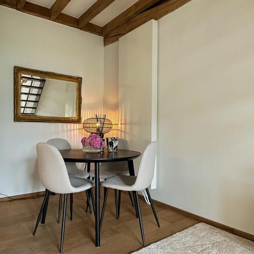 a dining room with a table and chairs and a mirror at Hoeve Berghof in Heerlen