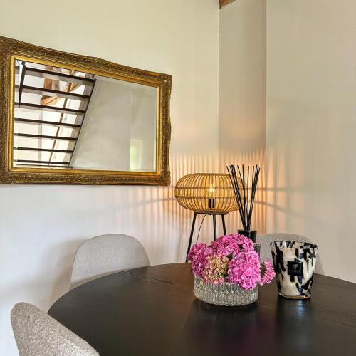 a table with a mirror and flowers on it at Hoeve Berghof in Heerlen