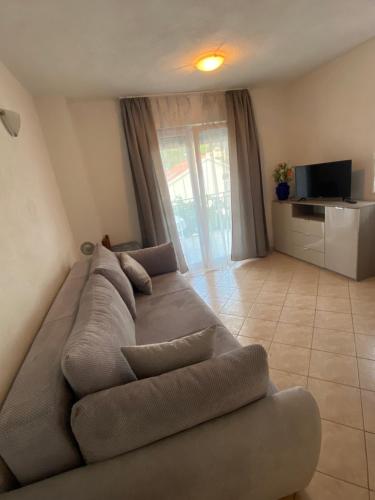 duża kanapa w salonie z telewizorem w obiekcie Apartments Šimić w Trogirze