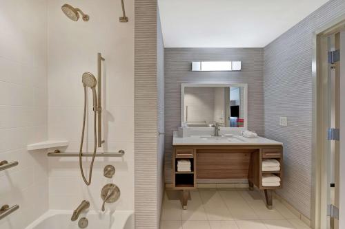 uma casa de banho com uma banheira, um lavatório e um chuveiro em Home2 Suites By Hilton West Palm Beach Airport em West Palm Beach