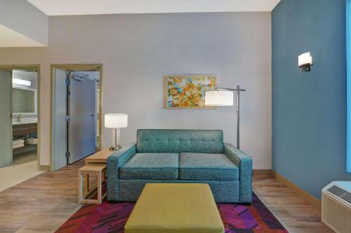 a living room with a couch and a table at Home2 Suites By Hilton West Palm Beach Airport in West Palm Beach