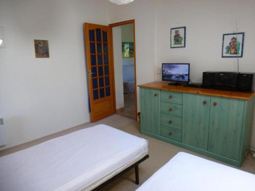 a bedroom with a bed and a tv on a dresser at Canigou 2 - Pinède avec piscine in Argelès-sur-Mer