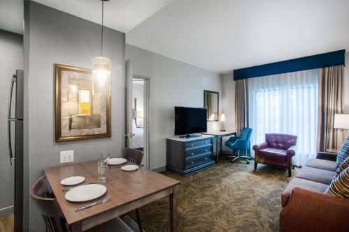 a hotel room with a table and a living room at Homewood Suites By Hilton Salina/Downtown, Ks in Salina