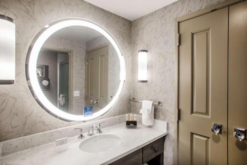 a bathroom with a sink and a mirror at Homewood Suites By Hilton Salina/Downtown, Ks in Salina