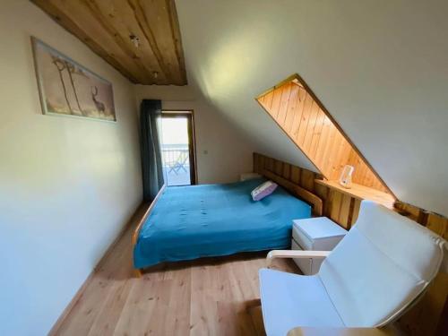 1 dormitorio con 1 cama azul y 1 silla en Forest springs. Family vacation tennis beach sauna, en GratiÅ¡kÄ—s