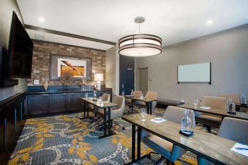 a conference room with tables and chairs and a screen at Homewood Suites By Hilton Salina/Downtown, Ks in Salina