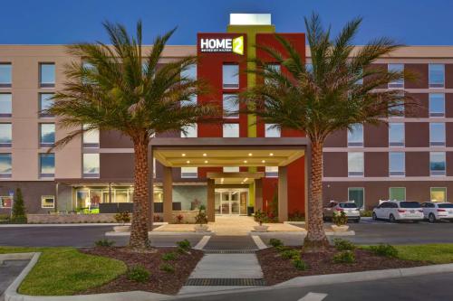 a hotel with two palm trees in front of it at Home2 Suites by Hilton, Sarasota I-75 Bee Ridge, Fl in Sarasota