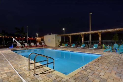 - une piscine de nuit avec des chaises et des tables dans l'établissement Home2 Suites by Hilton, Sarasota I-75 Bee Ridge, Fl, à Sarasota