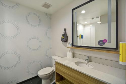 a bathroom with a toilet and a sink and a mirror at Tru By Hilton Winchester, Va in Winchester