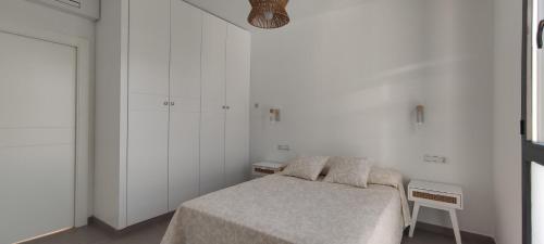 a bedroom with a bed and white walls at Casa Rural Reserva de las Nieves in Tolox