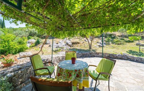 a table and chairs sitting under a pergola at Beautiful Home In Gruda With Wifi in Gruda